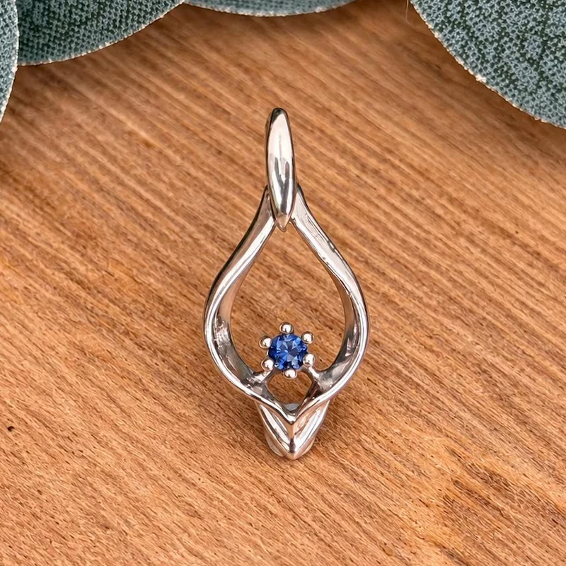 A blue California benitoite gemstone held in a white gold teardrop pendant